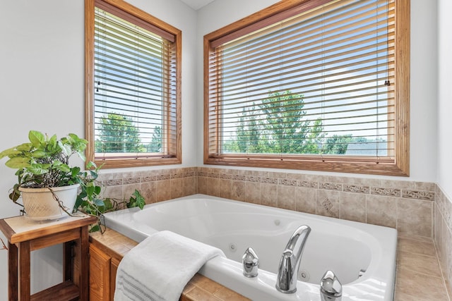 bathroom featuring tiled tub and a wealth of natural light