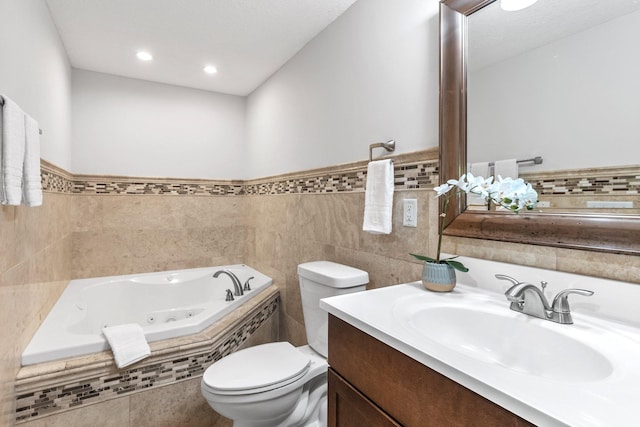 bathroom featuring vanity, a relaxing tiled tub, tile walls, and toilet