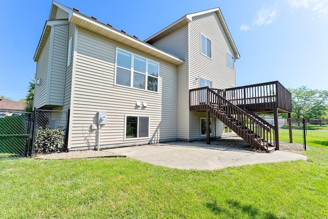 rear view of house featuring a wooden deck, a patio, and a lawn