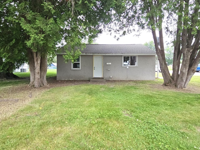 rear view of house featuring a lawn