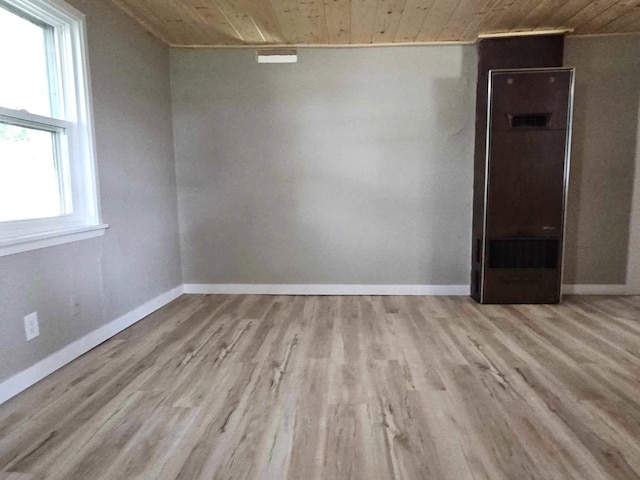 unfurnished room with wood ceiling and light hardwood / wood-style floors