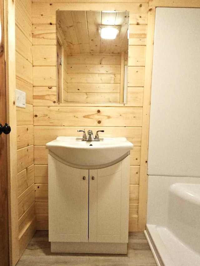 bathroom featuring vanity, wood walls, wood-type flooring, and wooden ceiling