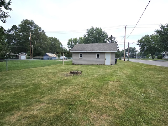 view of yard with an outdoor structure and an outdoor fire pit