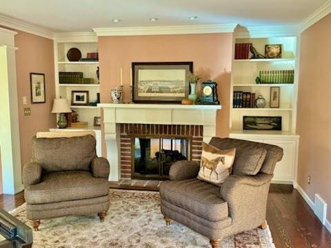 sitting room featuring ornamental molding, a fireplace, and hardwood / wood-style floors