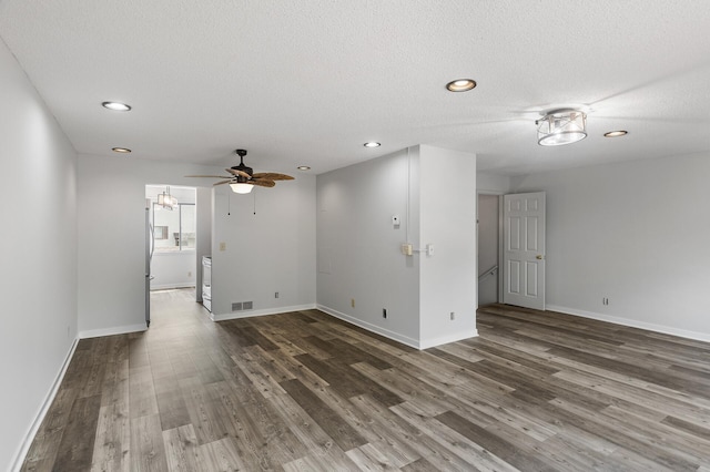 empty room with a textured ceiling, dark hardwood / wood-style floors, and ceiling fan