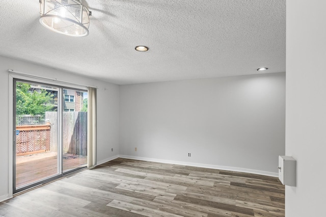 empty room with a textured ceiling and hardwood / wood-style floors