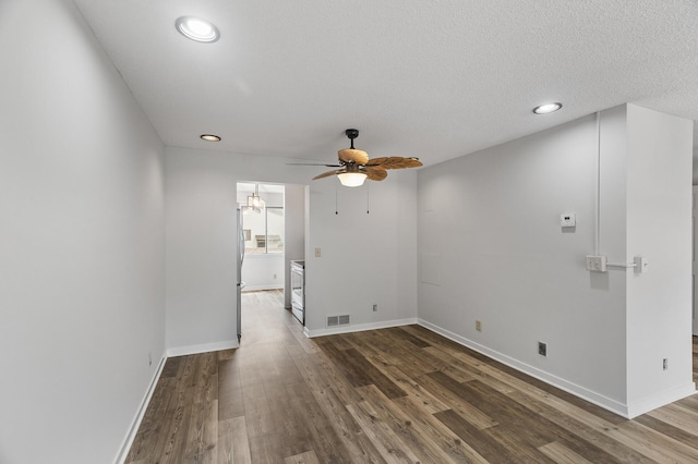 unfurnished room with ceiling fan, dark hardwood / wood-style floors, and a textured ceiling