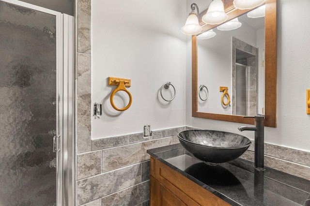 bathroom featuring vanity, tile walls, and a shower with shower door