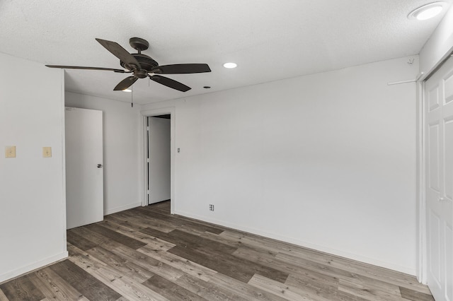 unfurnished bedroom featuring a closet, ceiling fan, hardwood / wood-style flooring, and a textured ceiling