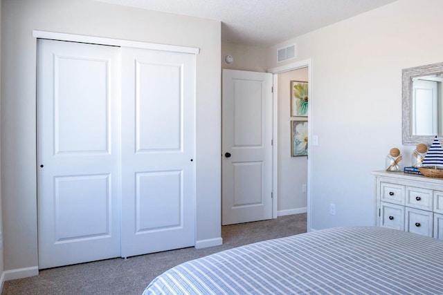 carpeted bedroom featuring baseboards, visible vents, and a closet