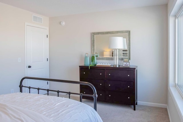 carpeted bedroom with visible vents and baseboards