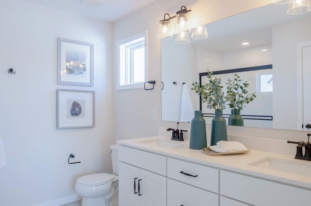 full bathroom with a sink, toilet, and double vanity