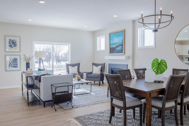 dining area with recessed lighting, baseboards, wood finished floors, and a glass covered fireplace