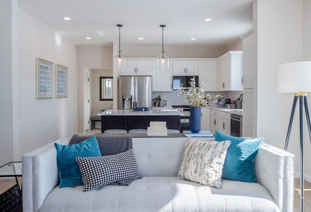 kitchen with a center island, pendant lighting, light countertops, appliances with stainless steel finishes, and white cabinets