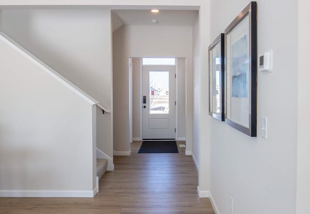 entrance foyer featuring stairway, baseboards, and wood finished floors