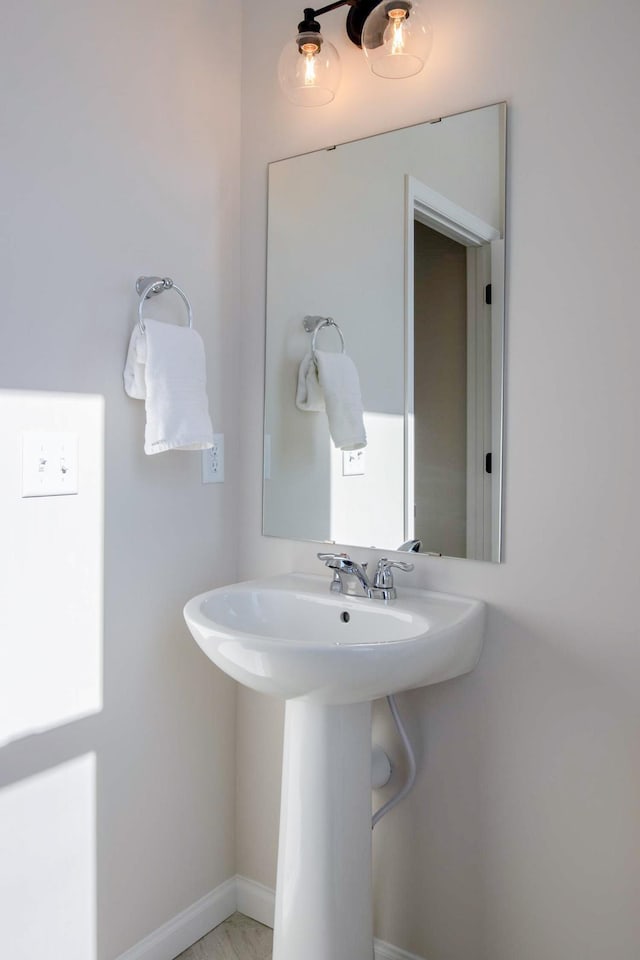 bathroom featuring baseboards and a sink