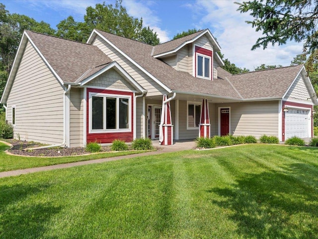 view of front of home featuring covered porch, a garage, and a front lawn