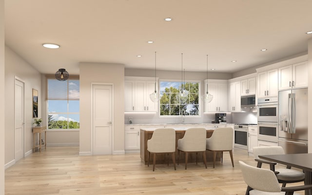 kitchen with light hardwood / wood-style floors, a wealth of natural light, appliances with stainless steel finishes, and white cabinets