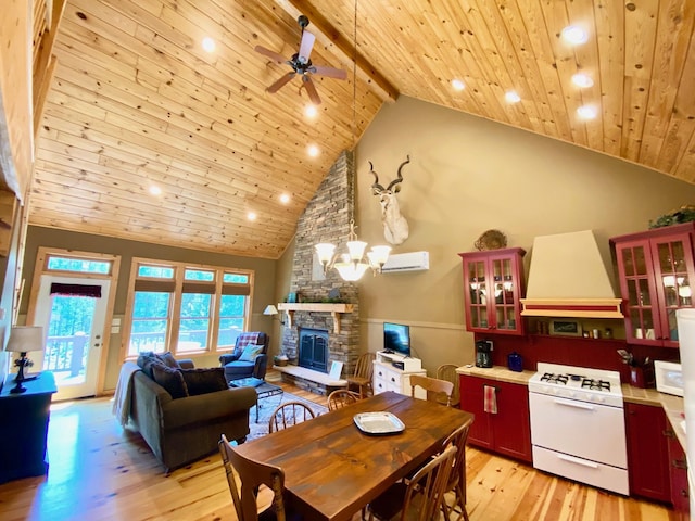 dining area featuring beam ceiling, light hardwood / wood-style flooring, high vaulted ceiling, and a stone fireplace