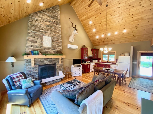 living room with high vaulted ceiling, a fireplace, light hardwood / wood-style floors, and a healthy amount of sunlight