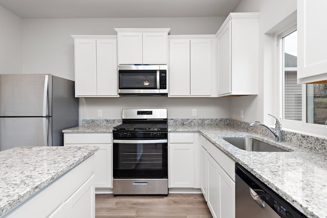 kitchen featuring light hardwood / wood-style floors, sink, white cabinetry, and stainless steel appliances