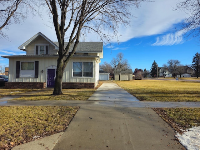 view of front facade featuring a garage, an outdoor structure, and a front lawn