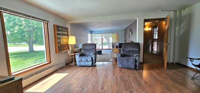 sitting room with wood-type flooring and a baseboard heating unit