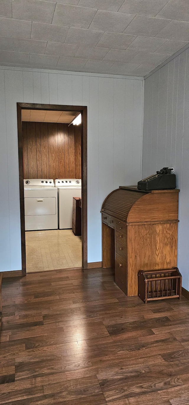 interior space with washer and dryer, wood walls, and dark hardwood / wood-style flooring