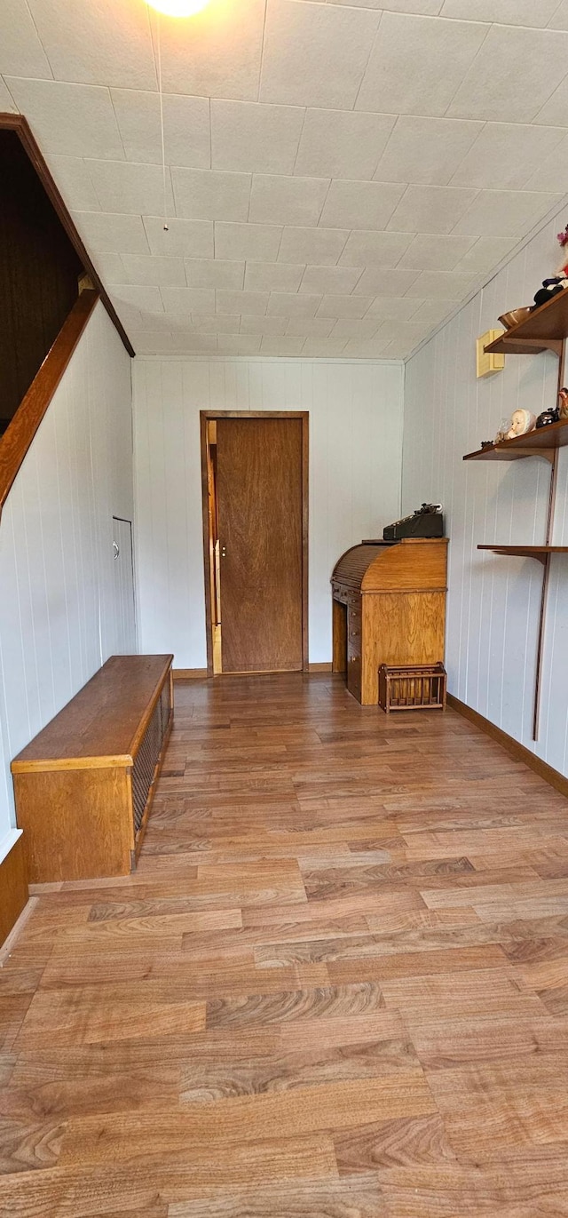 unfurnished living room featuring wood walls and light hardwood / wood-style flooring