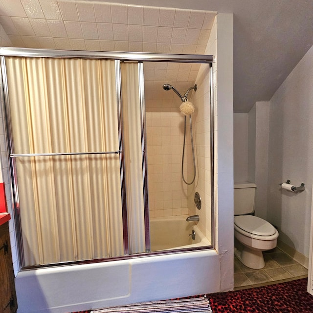 bathroom with tile patterned flooring, toilet, and bath / shower combo with glass door