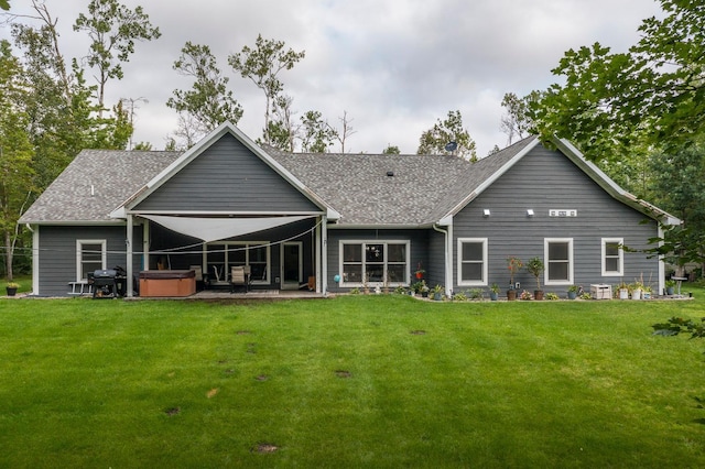 back of house with central air condition unit, a hot tub, a yard, and a patio