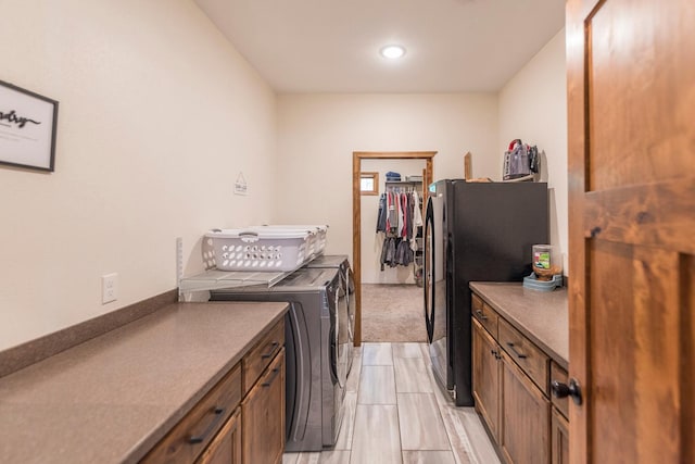 clothes washing area featuring cabinets and washer and dryer