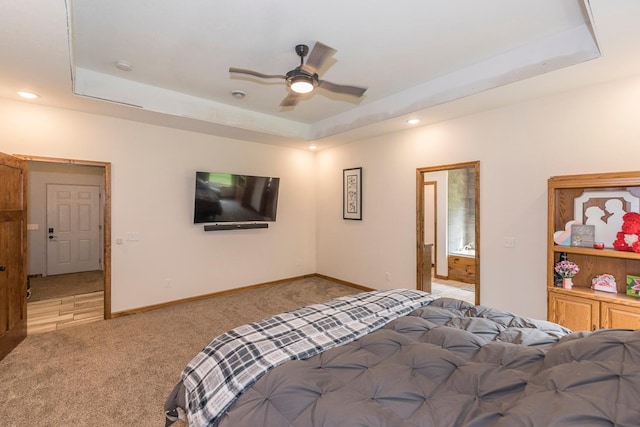 bedroom with ceiling fan, carpet flooring, and a raised ceiling