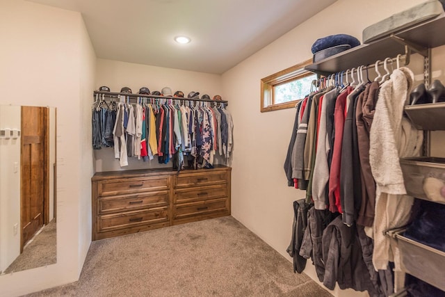 walk in closet featuring light colored carpet