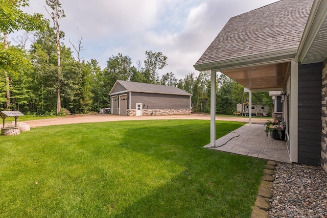 view of yard featuring a garage and an outbuilding