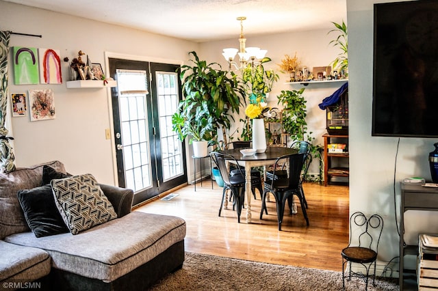 dining space with light hardwood / wood-style flooring and a notable chandelier