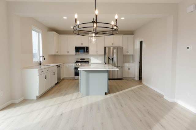 kitchen featuring white cabinets, pendant lighting, stainless steel appliances, and a kitchen island