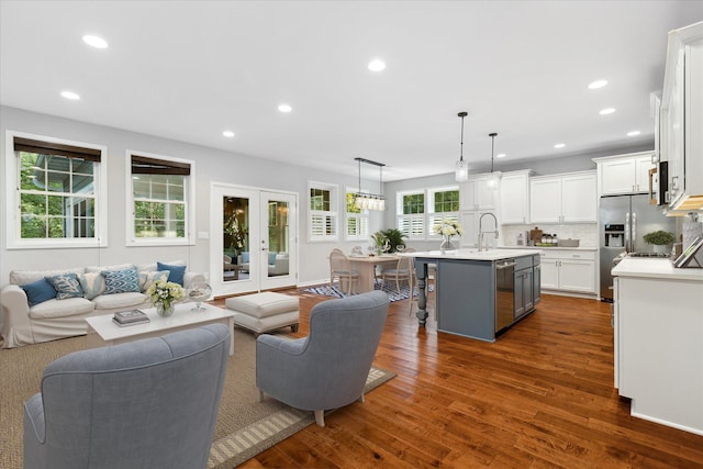 living room with dark wood-type flooring, sink, and french doors