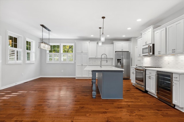 kitchen with hanging light fixtures, white cabinets, wine cooler, and appliances with stainless steel finishes