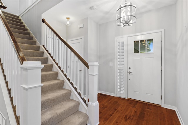 entryway with dark hardwood / wood-style floors and a chandelier