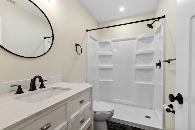 bathroom featuring walk in shower, vanity, toilet, and tile patterned flooring