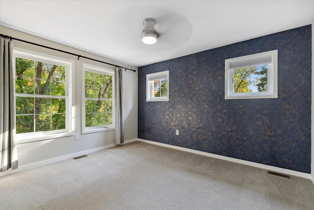 carpeted spare room with ceiling fan