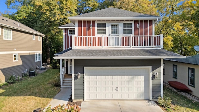 view of front facade with a balcony, a garage, and a front yard