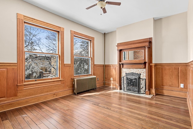 182 Kent St Unit 3, Saint Paul, MN 55102 - unfurnished living room with a wainscoted wall, ceiling fan, radiator heating unit, and light wood-style floors