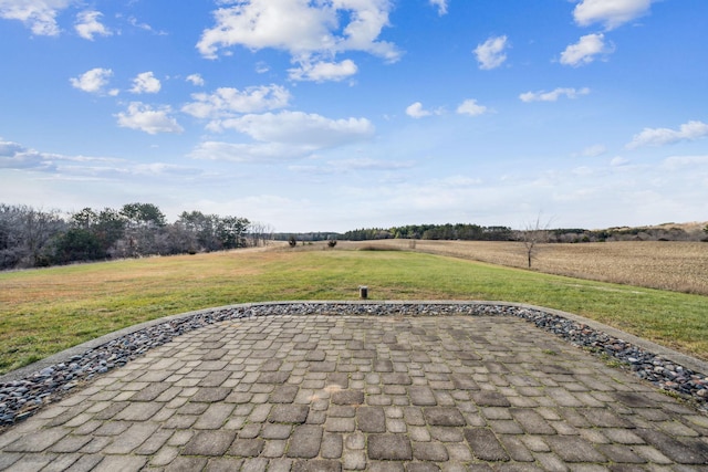 view of community with a rural view and a lawn