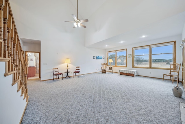 unfurnished room featuring ceiling fan, carpet floors, and a high ceiling