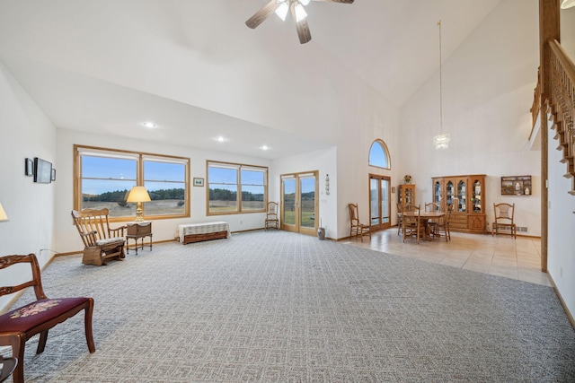 living area with ceiling fan, high vaulted ceiling, and light colored carpet