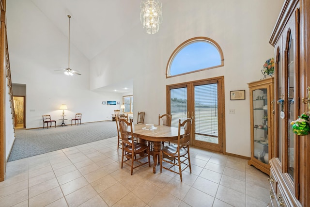 dining area with ceiling fan with notable chandelier, light tile patterned floors, and lofted ceiling