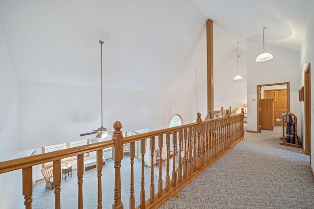 hall featuring carpet and high vaulted ceiling