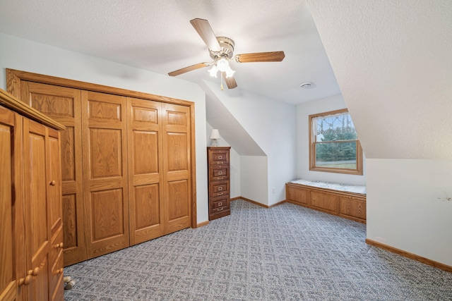 bonus room with light colored carpet, vaulted ceiling, ceiling fan, and a textured ceiling